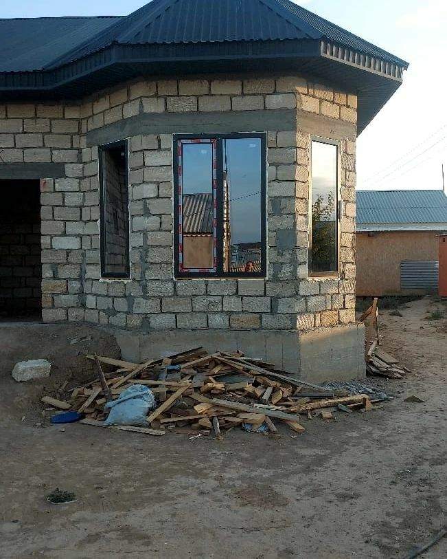 Два окна с ламинированным профилем в стене из ракушечника на этапе строительства дома в Атырау